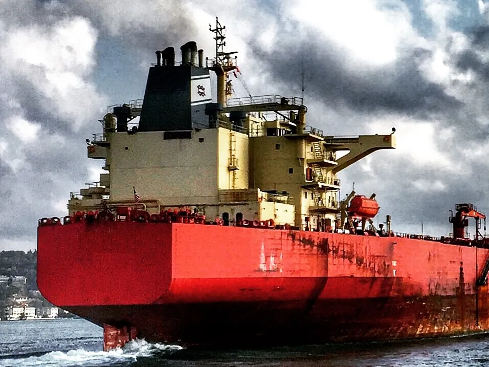 A loaded tanker at anchor under a dramatic sky